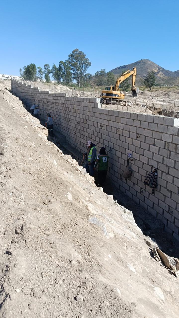 Construcción de muro de mampostería con excavadora